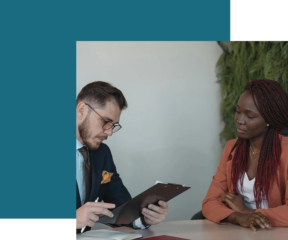 A man and woman are looking at an ipad.