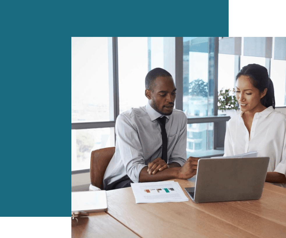 Two people sitting at a table with a laptop