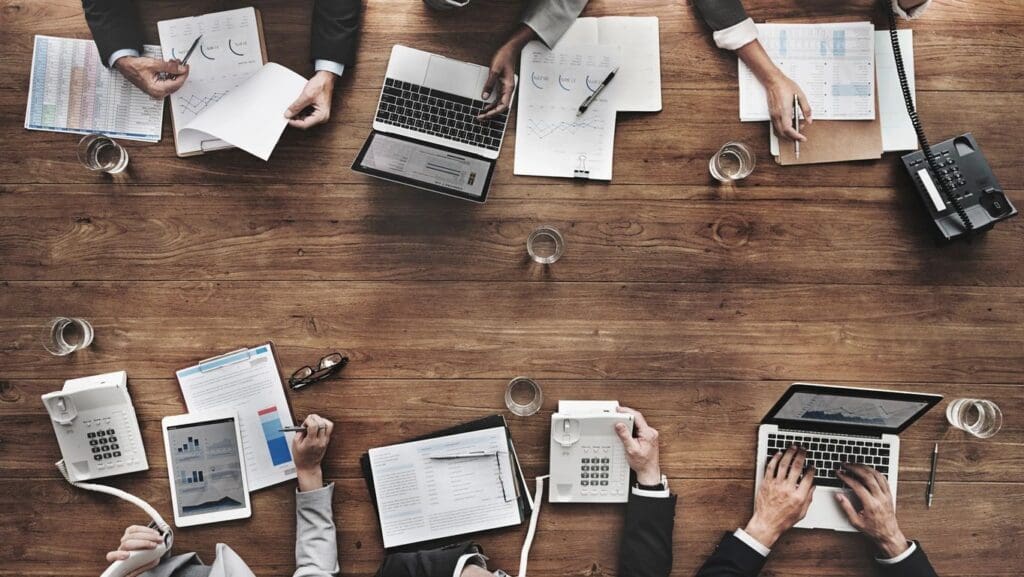 Table full of computers and financials, calculating costs of the open position
